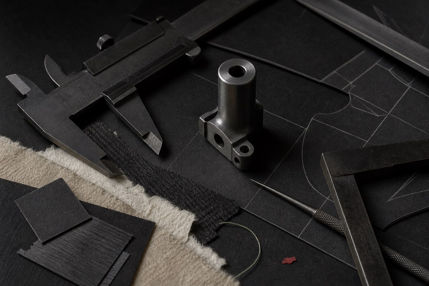 Estudio técnico neutral con herramientas oscuras, una pieza sin marca y muestras de materiales sobre washi.